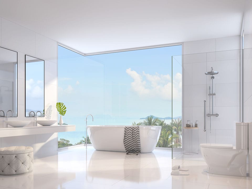 freestanding tub in front of large corner windows